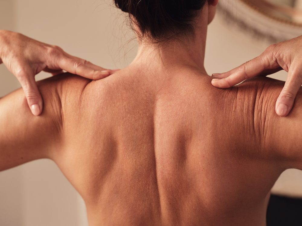 Woman performing Yoga Stretches, placing her hands on her shoulders