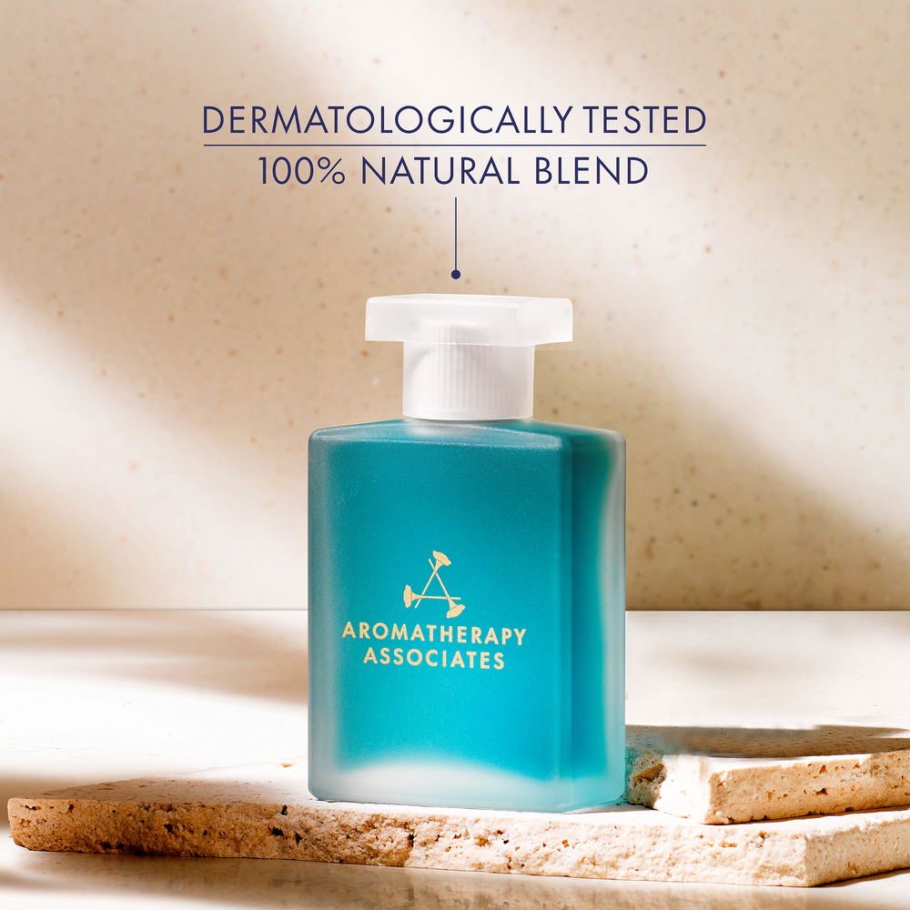 Blue bottle with white cap labeled 'Aromatherapy Associates' calm confidence on a beige background