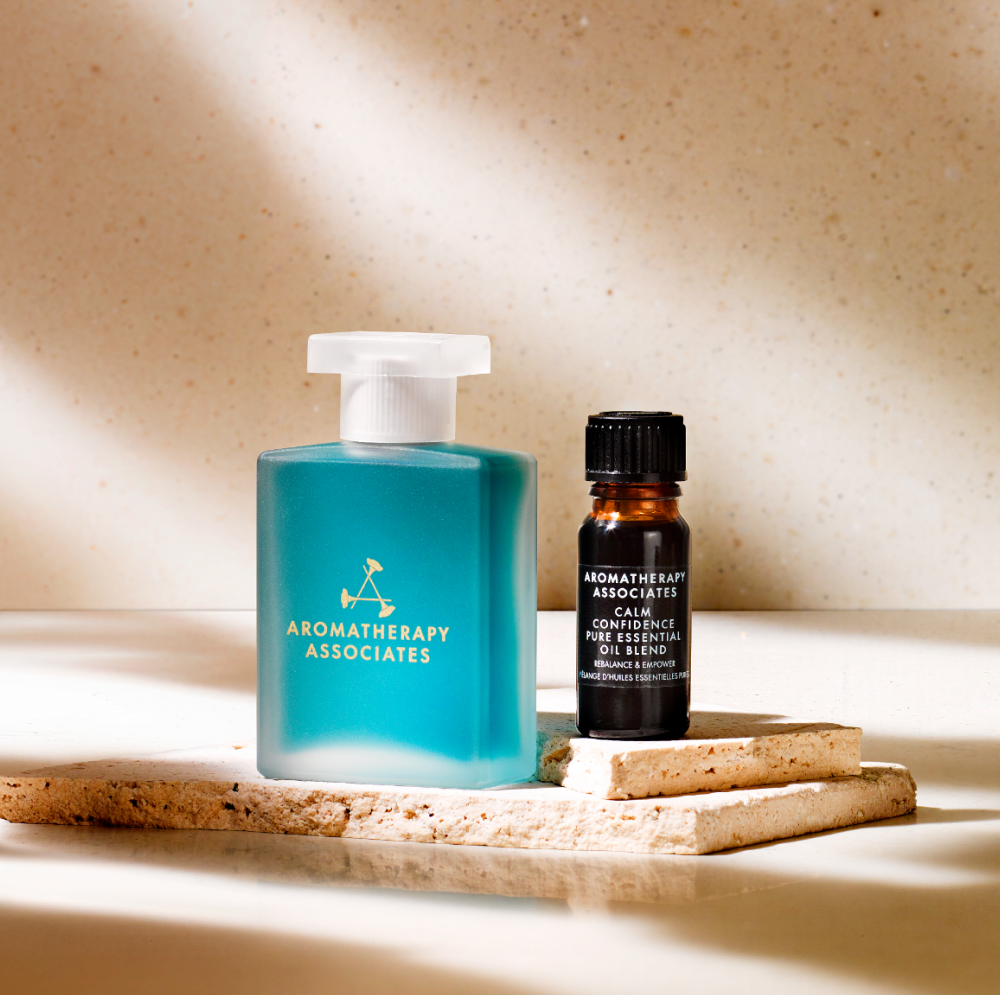 Two Aromatherapy Associates products on a textured surface with a neutral background