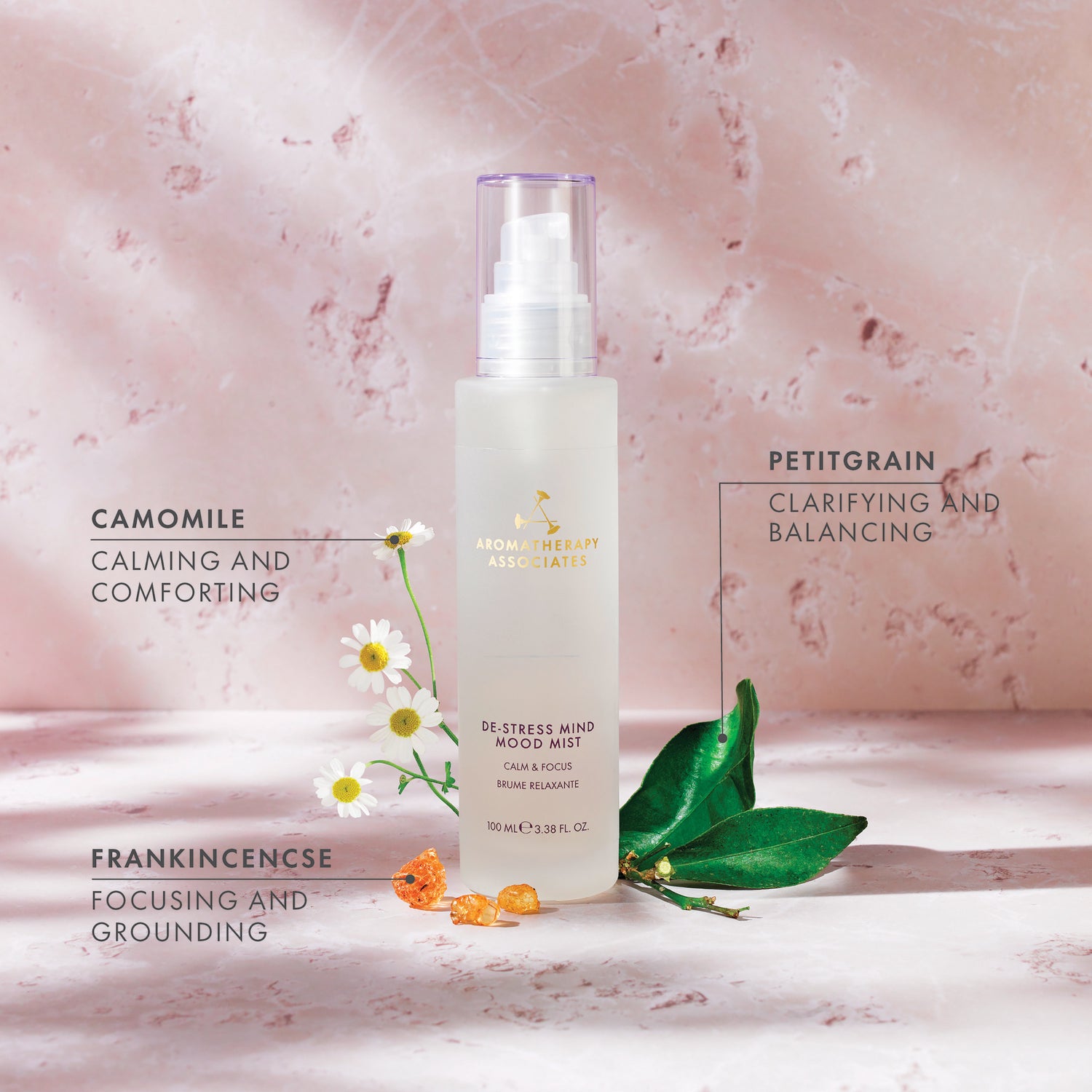 Skincare product with botanical elements on a pink marble background