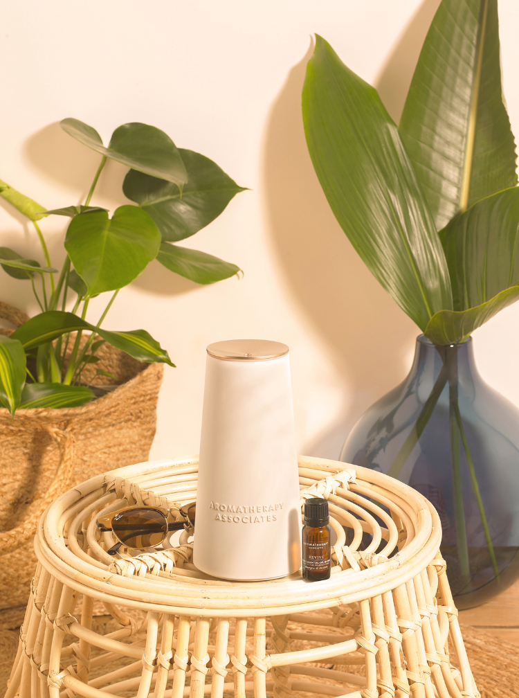 The Atomiser on a woven stool, surrounded by plants and a vase.