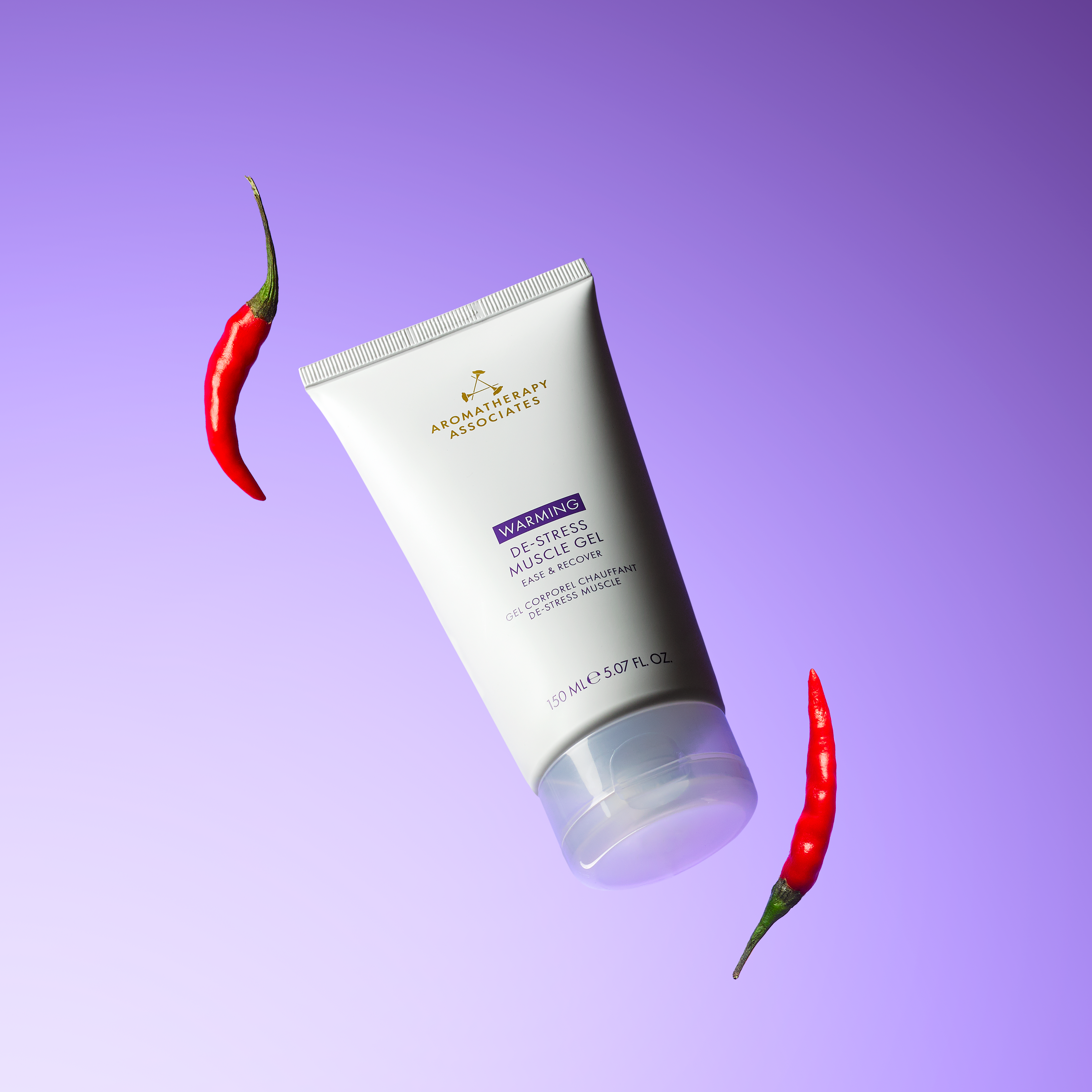 Tube of Aromatherapy Associates muscle gel with red chili peppers on a purple background