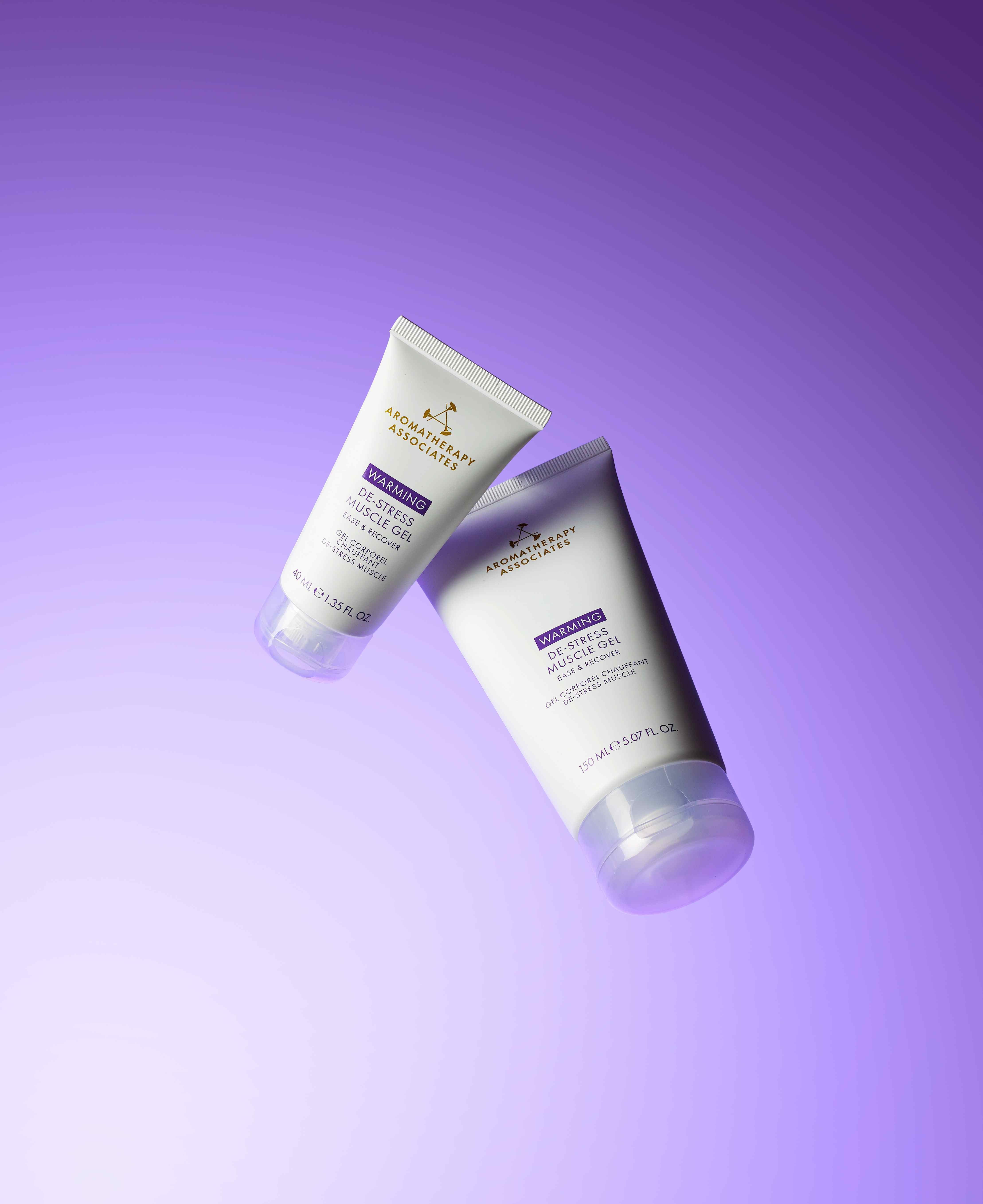 Two tubes of Aromatherapy Associates Warming De-Stress Muscle Gel on a purple background