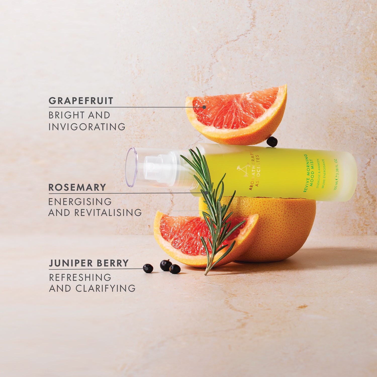 Skincare product with grapefruit, rosemary, and juniper berry elements on a light background