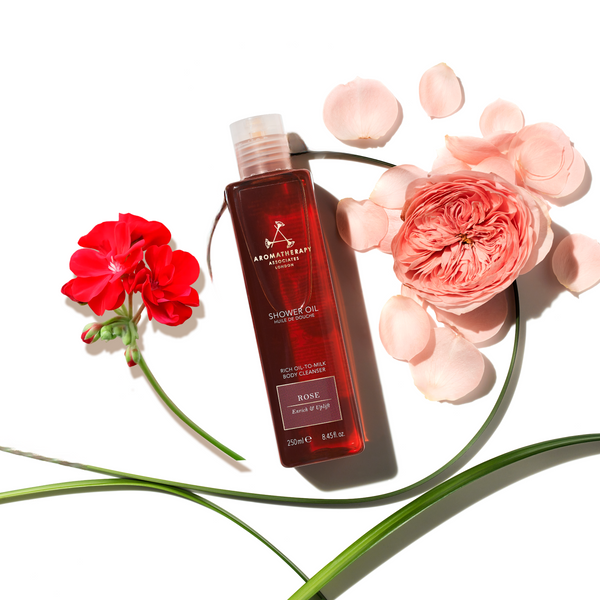 Shower oil bottle with flowers and petals on a white background